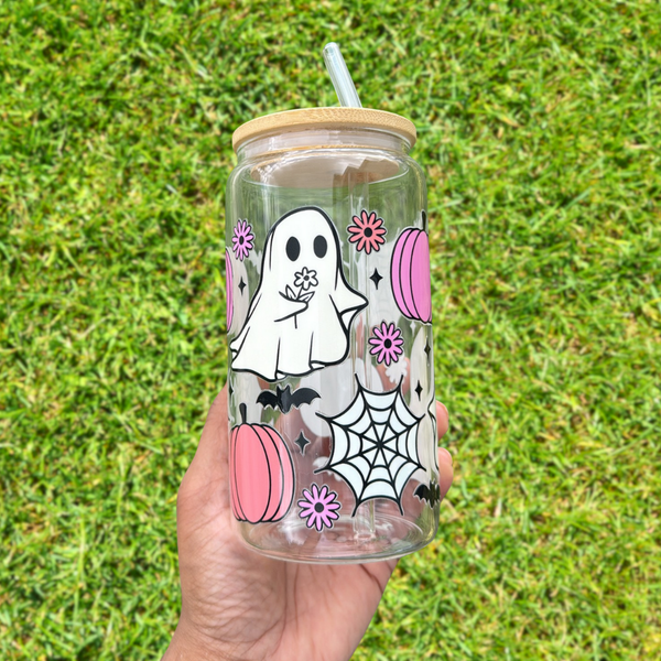 Clear glass can tumbler with elegant Halloween-themed designs featuring ghosts holding daisies, and surrounded by cute bat and pumpkin graphics.