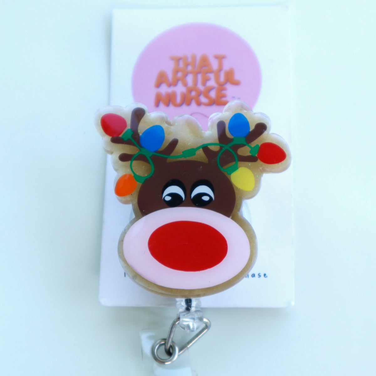 Acrylic Christmas reindeer badge reel with glitter finish, red nose, and colorful lights on antlers.