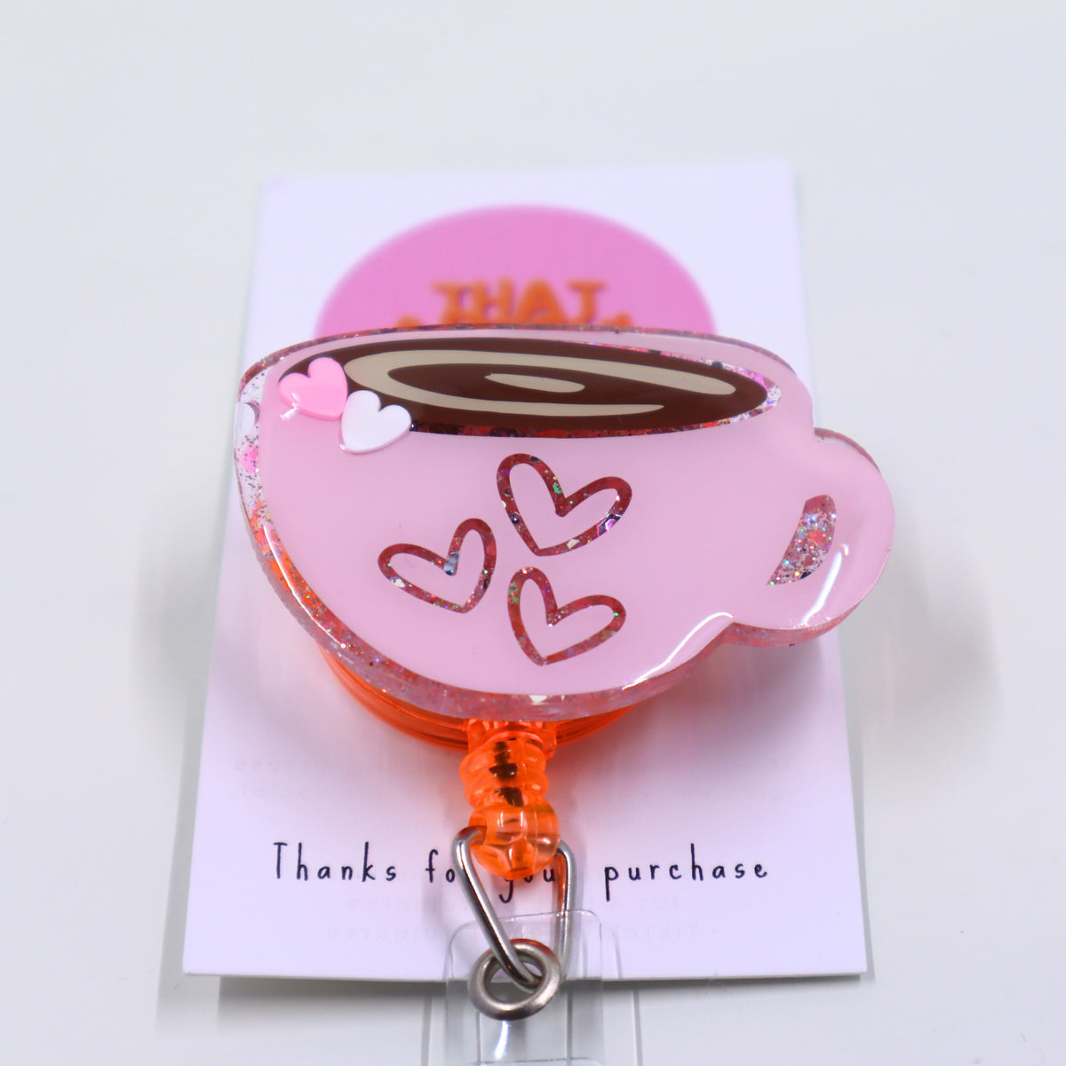 A charming pink expresso coffee cup with hearts, featured on a badge reel. Perfect for valentine's day.