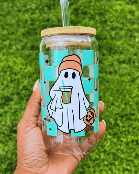 Clear glass can-style cup featuring a playful ghost and a turquoise checkered pattern with bats, complete with a reusable straw—perfect for spooky season.