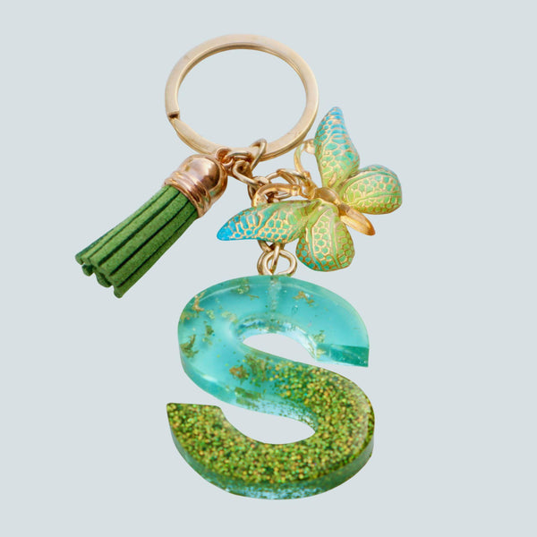 Customizable keychain with green tassel and butterfly charm on a light blue background.