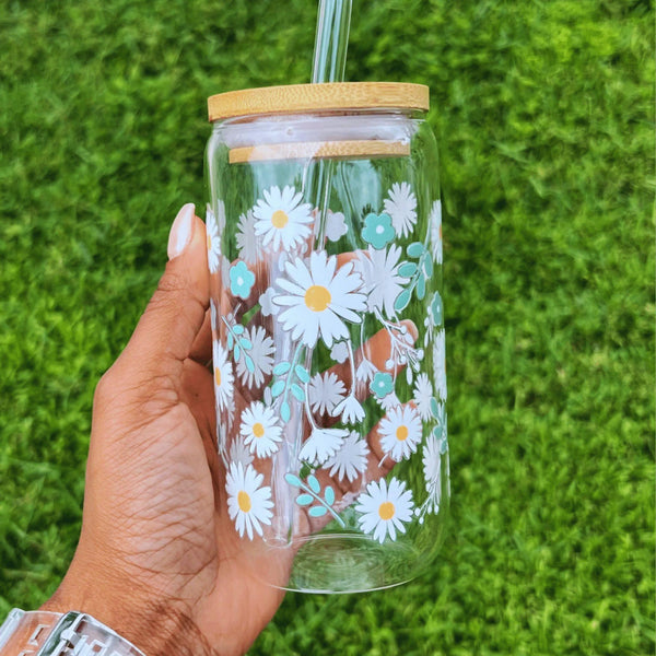 A 16oz clear glass can featuring a beautiful daisies design.