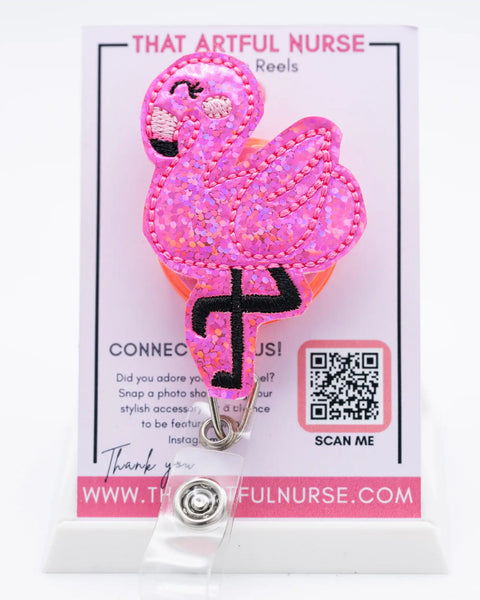 Flamingle - pink glitter embroidered flamingo badge reel featuring smiling face and tropical leaves for nurses and professionals.