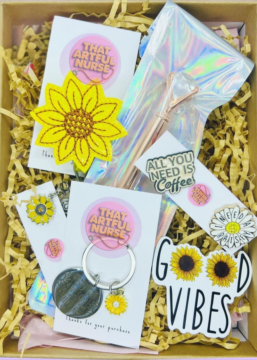 Box of assorted items including stickers and a keychain with text and graphics on a purple background