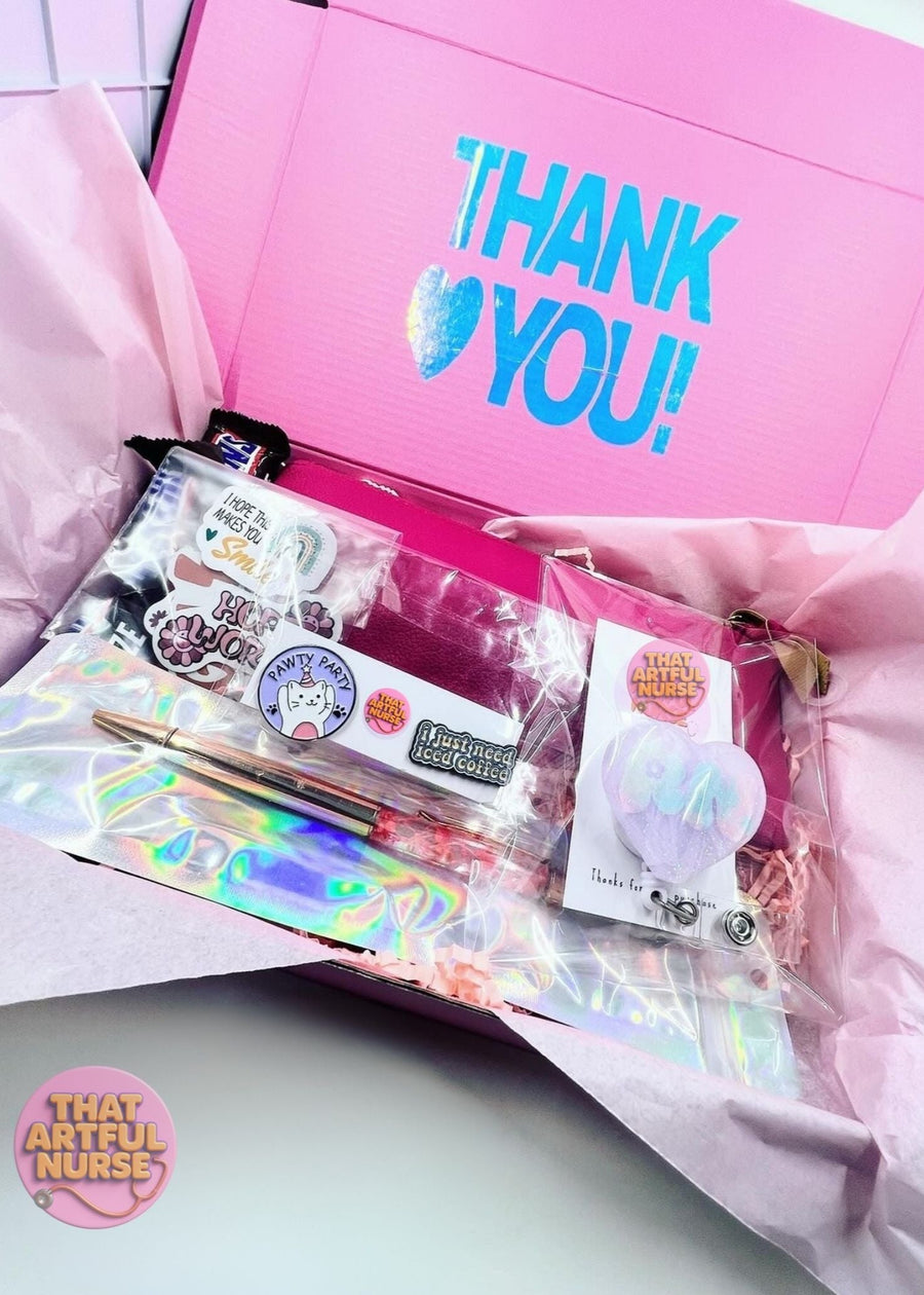 Pink gift box with 'THANK YOU!' text, stationery items, and a visible brand logo.