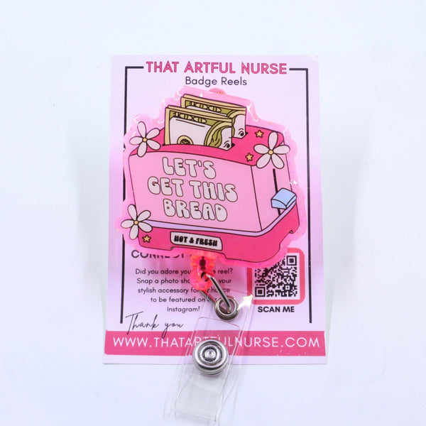"A pink acrylic badge reel featuring a toaster with two slices of 100 dollar bills, white flowers, stars, and the phrase 'LET'S GET THIS BREAD – NOT A PHASE' on a rectangular design."