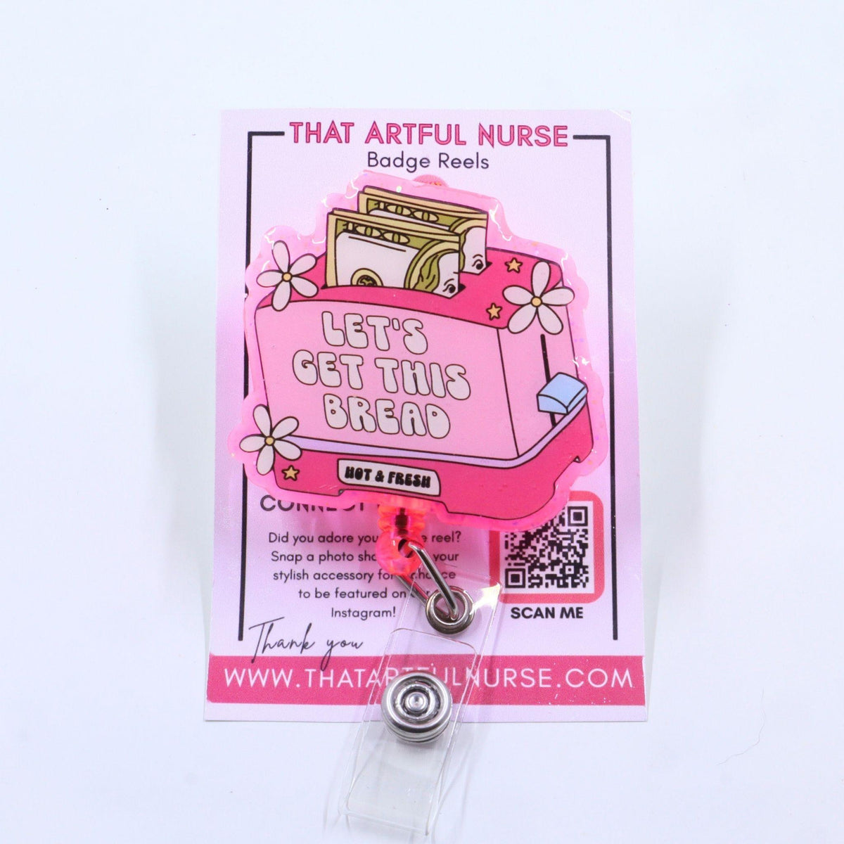 "A pink acrylic badge reel featuring a toaster with two slices of 100 dollar bills, white flowers, stars, and the phrase 'LET'S GET THIS BREAD – NOT A PHASE' on a rectangular design."