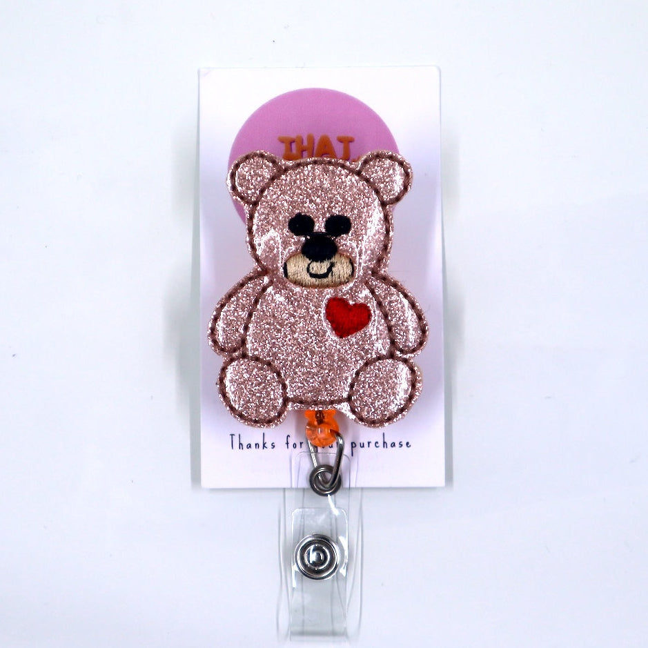 Glittery teddy bear badge holder with a pink heart on a white background