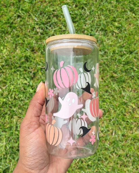 16oz Halloween-themed glass can with bamboo lid and reusable glass straw; decorated with pastel pumpkins, ghosts, crescent moons, and stars on a grassy background.