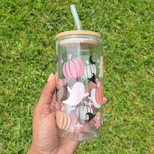 16oz Halloween-themed glass can with bamboo lid and reusable glass straw; decorated with pastel pumpkins, ghosts, crescent moons, and stars on a grassy background.