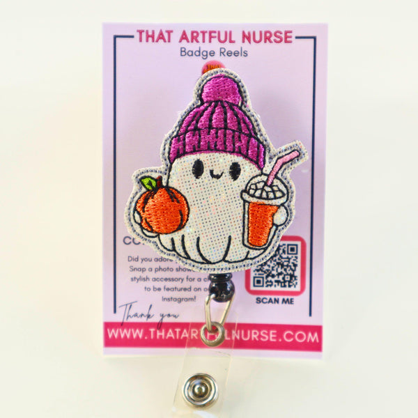 Embroidered ghost badge reel wearing a purple beanie, holding a pumpkin and a drink.