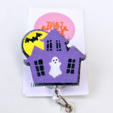 A badge reel featuring a purple haunted house with a ghost and a full moon in the background.