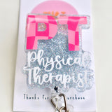 A physical therapist badge reel with two shades of pink colors featuring a checkered design, attached to an ID clip.