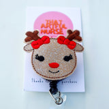 Reindeer-inspired badge reel with glittery face, red nose, lashes, and red bows on antlers.